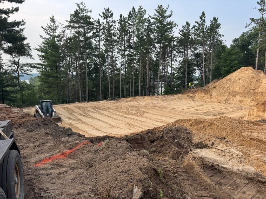 Site grading and excavation with skid steer and surveying equipment